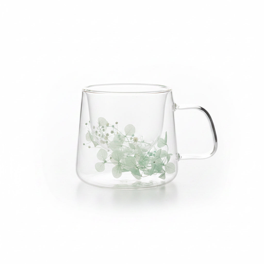 taza de vidrio con flores celestes para infusión
